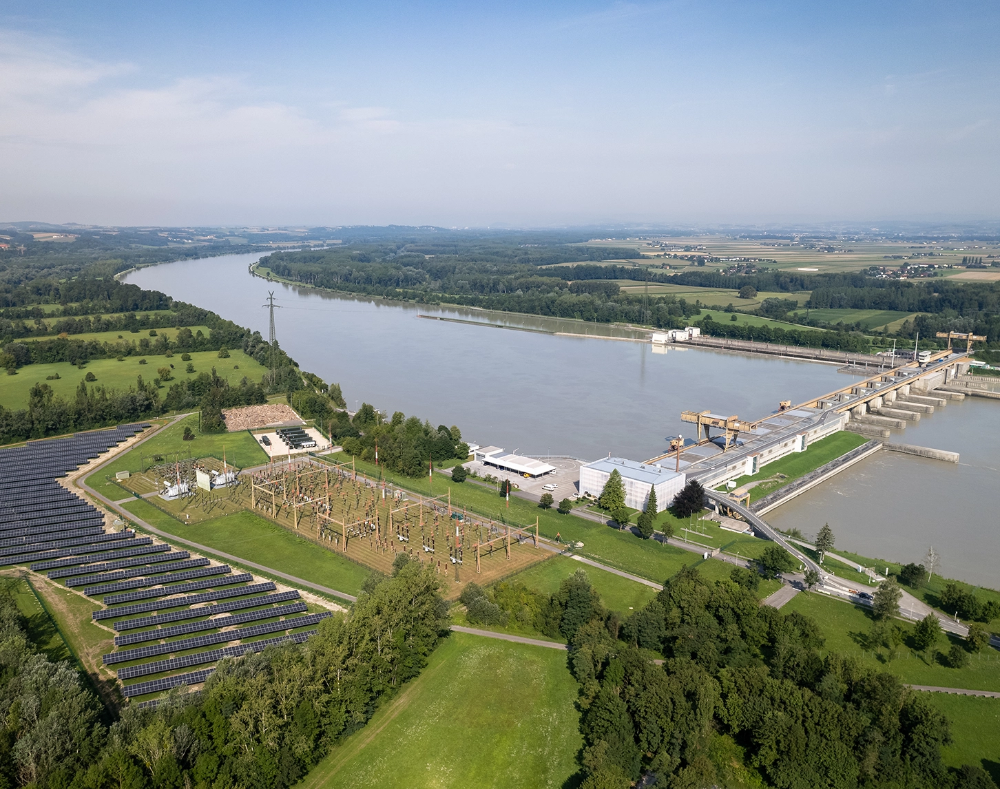 Wir blicken auf Wasserkraftwerk Wallsee Mitterkirchen. Auf der linken Seite sehen wir zudem eine Photovoltaikanlage.