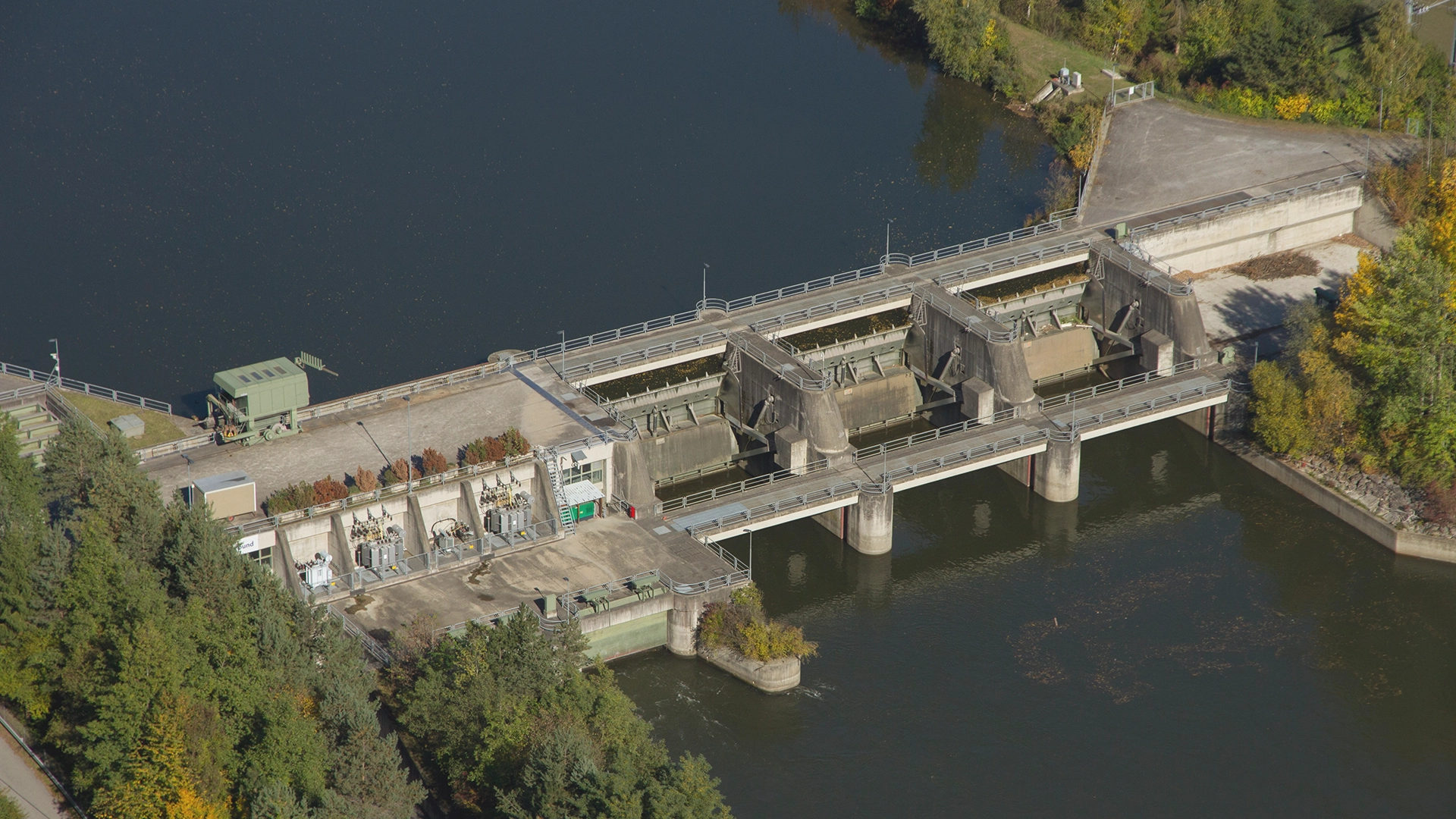 Wir blicken von oben auf das Laufkraftwerk Rabenstein an der Mur. Die Stimmung ist herbstlich.